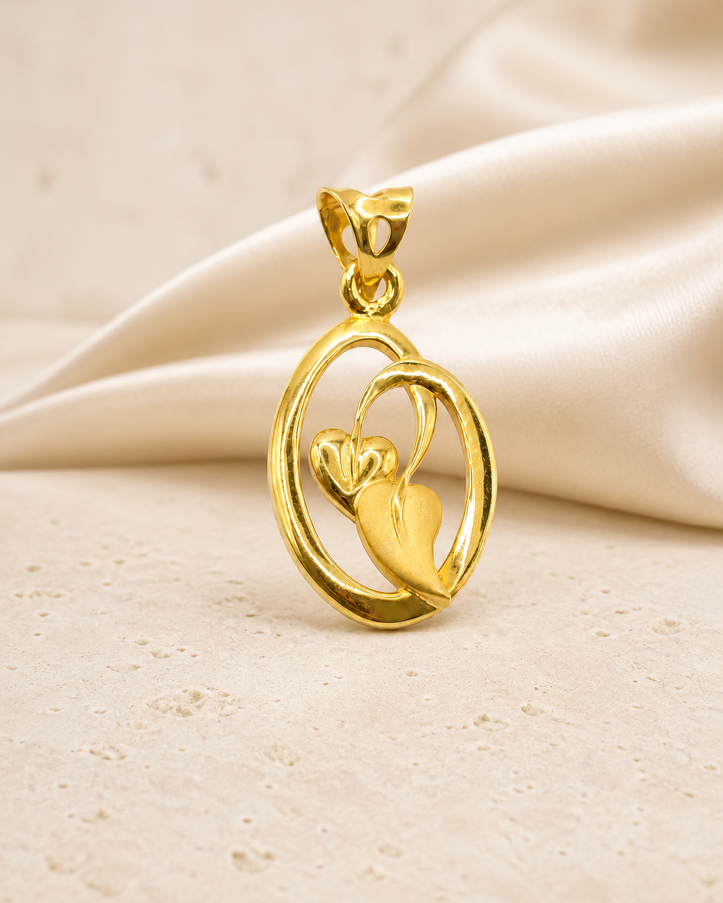 Dual-leaf gold pendant styled on champagne silk and ivory stone
