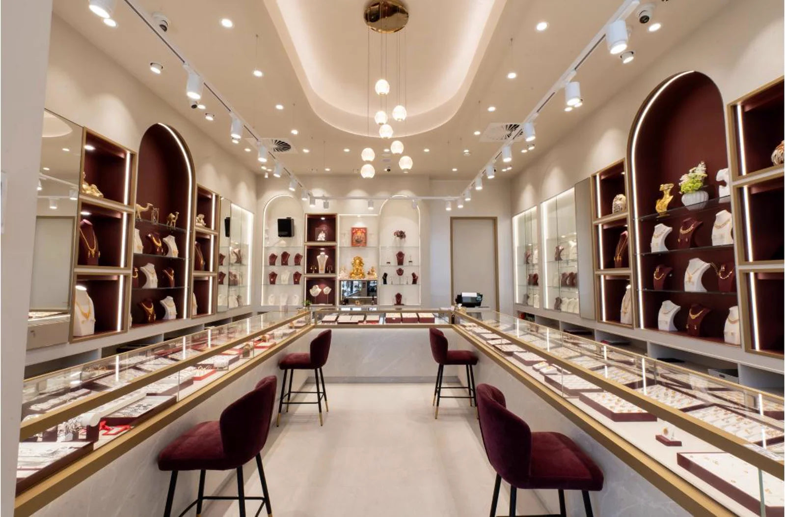 Inside the bright Kohinoor Gold Jewellery boutique with illuminated jewellery displays and seated counters